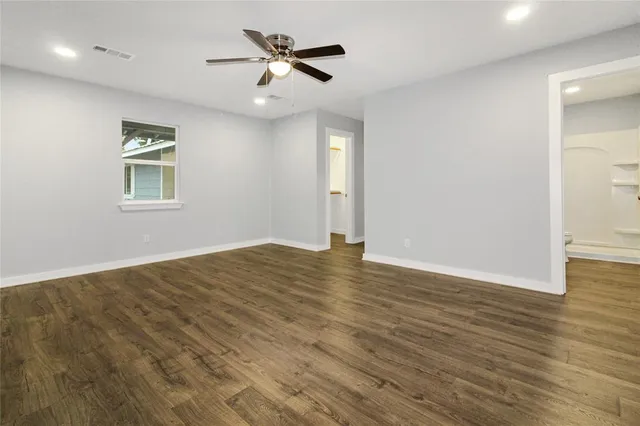 a view of empty room with wooden floor