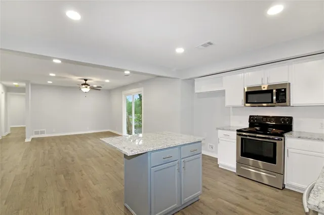 a kitchen with stainless steel appliances granite countertop a sink and a stove top oven