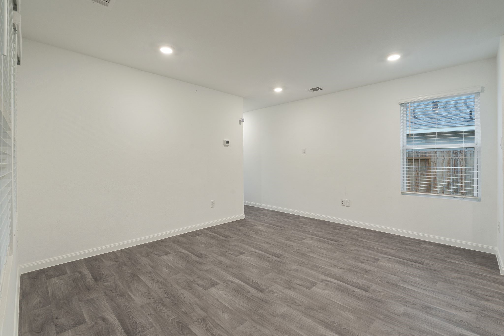 12070 William Trails Circle Willis, TX 77378 - Photo 6 of 18 an empty room with wooden floor and windows