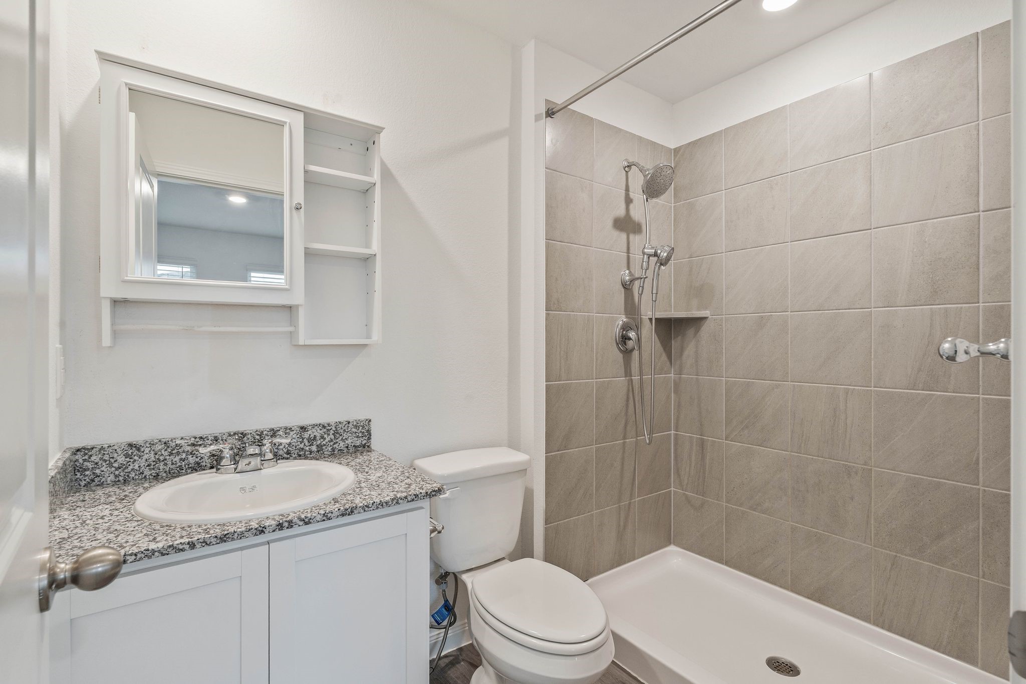 12070 William Trails Circle Willis, TX 77378 - Photo 9 of 18 a bathroom with a granite countertop sink a toilet and shower