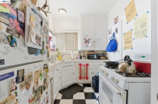 a kitchen with a sink dishwasher and white cabinets with wooden floor