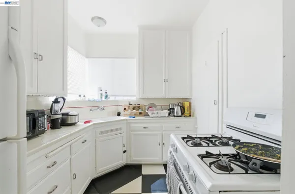 a kitchen with white cabinets and appliances