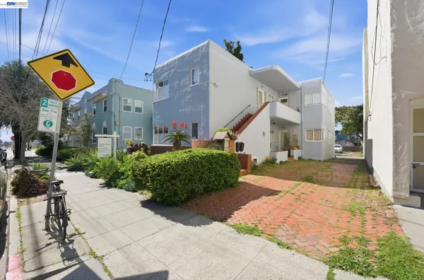 a street sign on a sidewalk next to a building