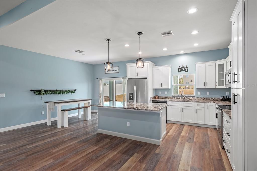2839 Northeast 43rd Road Ocala, FL 34470 - Photo 14 of 50 a kitchen with stainless steel appliances granite countertop a stove refrigerator and a wooden floors
