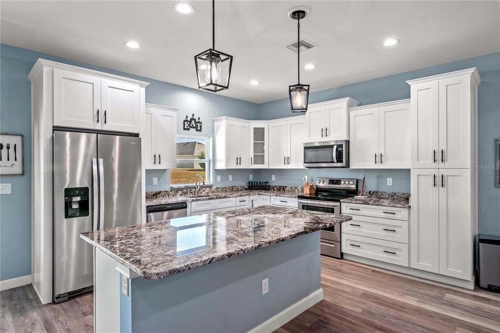 2839 Northeast 43rd Road Ocala, FL 34470 - Photo 15 of 50 a kitchen with stainless steel appliances granite countertop a sink refrigerator and cabinets