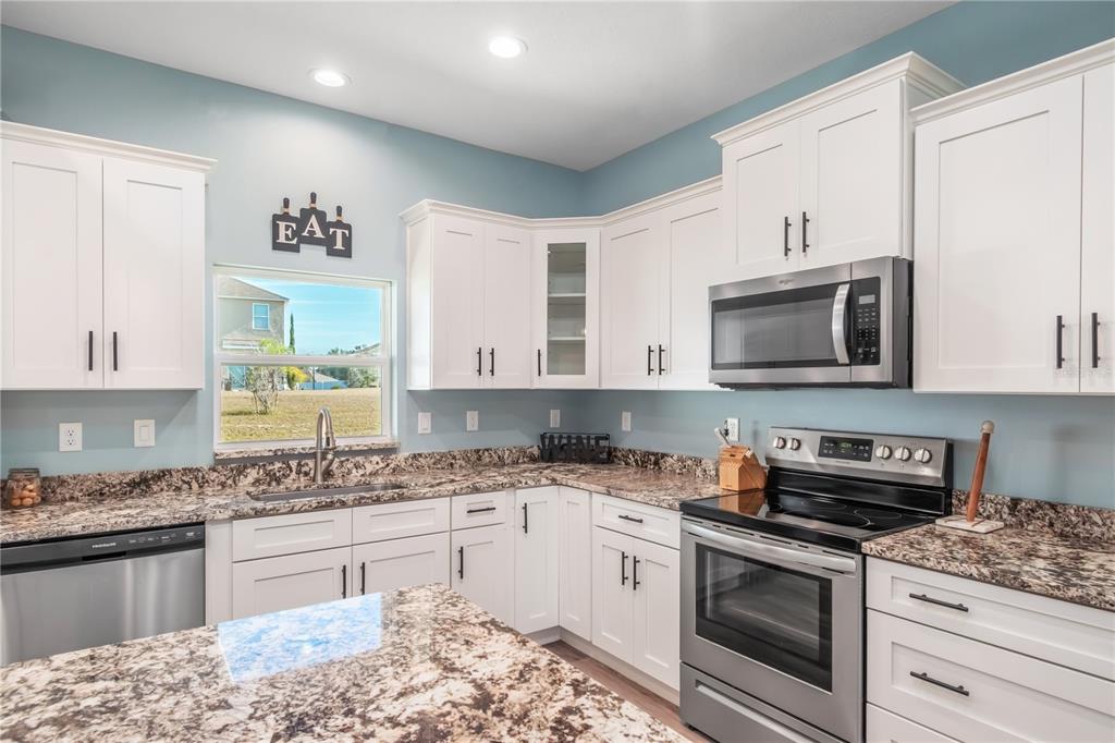 2839 Northeast 43rd Road Ocala, FL 34470 - Photo 16 of 50 a kitchen with stainless steel appliances granite countertop a stove a sink and a microwave