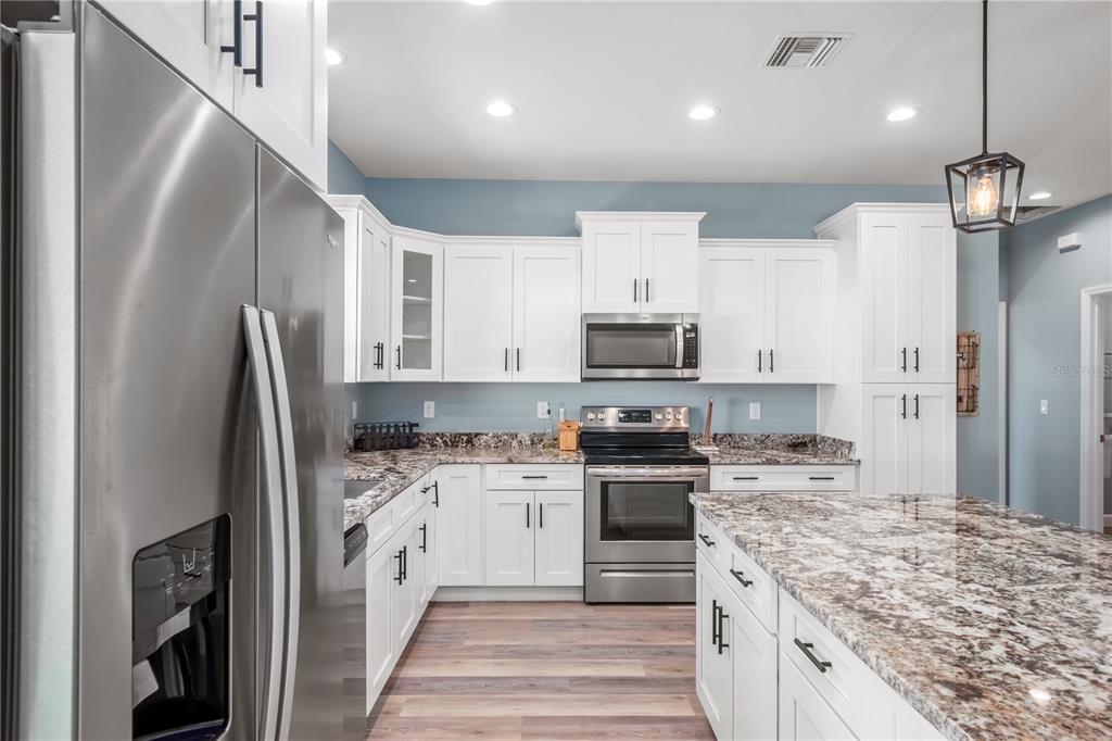 2839 Northeast 43rd Road Ocala, FL 34470 - Photo 18 of 50 a large kitchen with stainless steel appliances granite countertop a stove a sink and a refrigerator