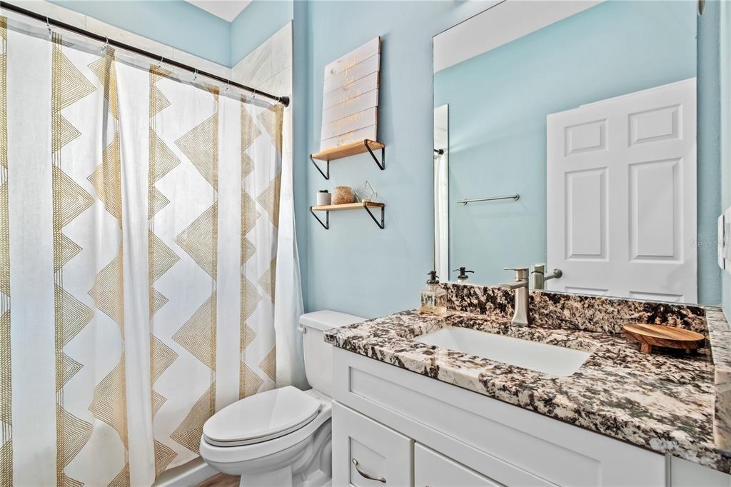 2839 Northeast 43rd Road Ocala, FL 34470 - Photo 33 of 50 a bathroom with a granite countertop sink and a mirror with toilet