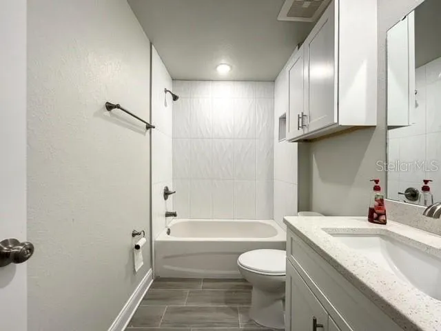 a bathroom with a granite countertop sink toilet and shower