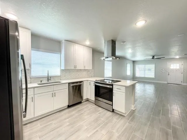 a kitchen with stainless steel appliances granite countertop a stove a sink and a refrigerator