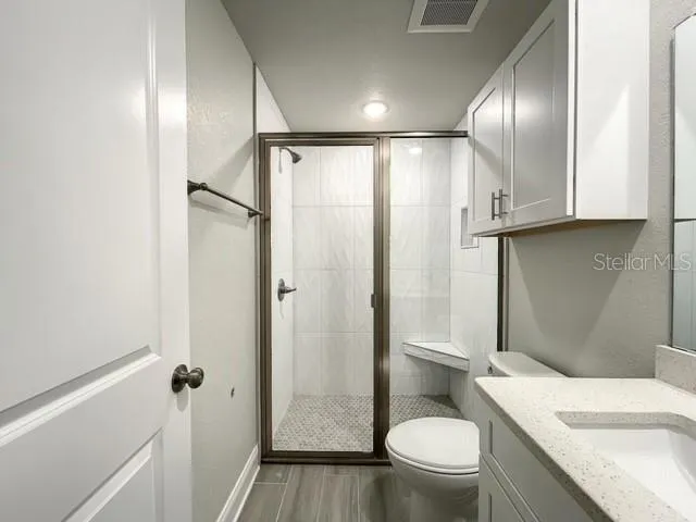 a bathroom with a granite countertop sink toilet and shower