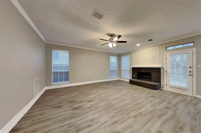 wooden floor fireplace and windows in an empty room