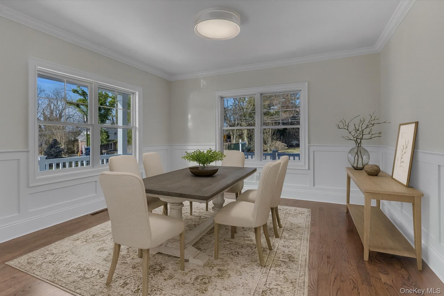 44 North Woodhull Road Huntington, NY 11743 - Photo 12 of 26 Dining room featuring plenty of natural light, wood finished floors, a wainscoted wall, and ornamental molding