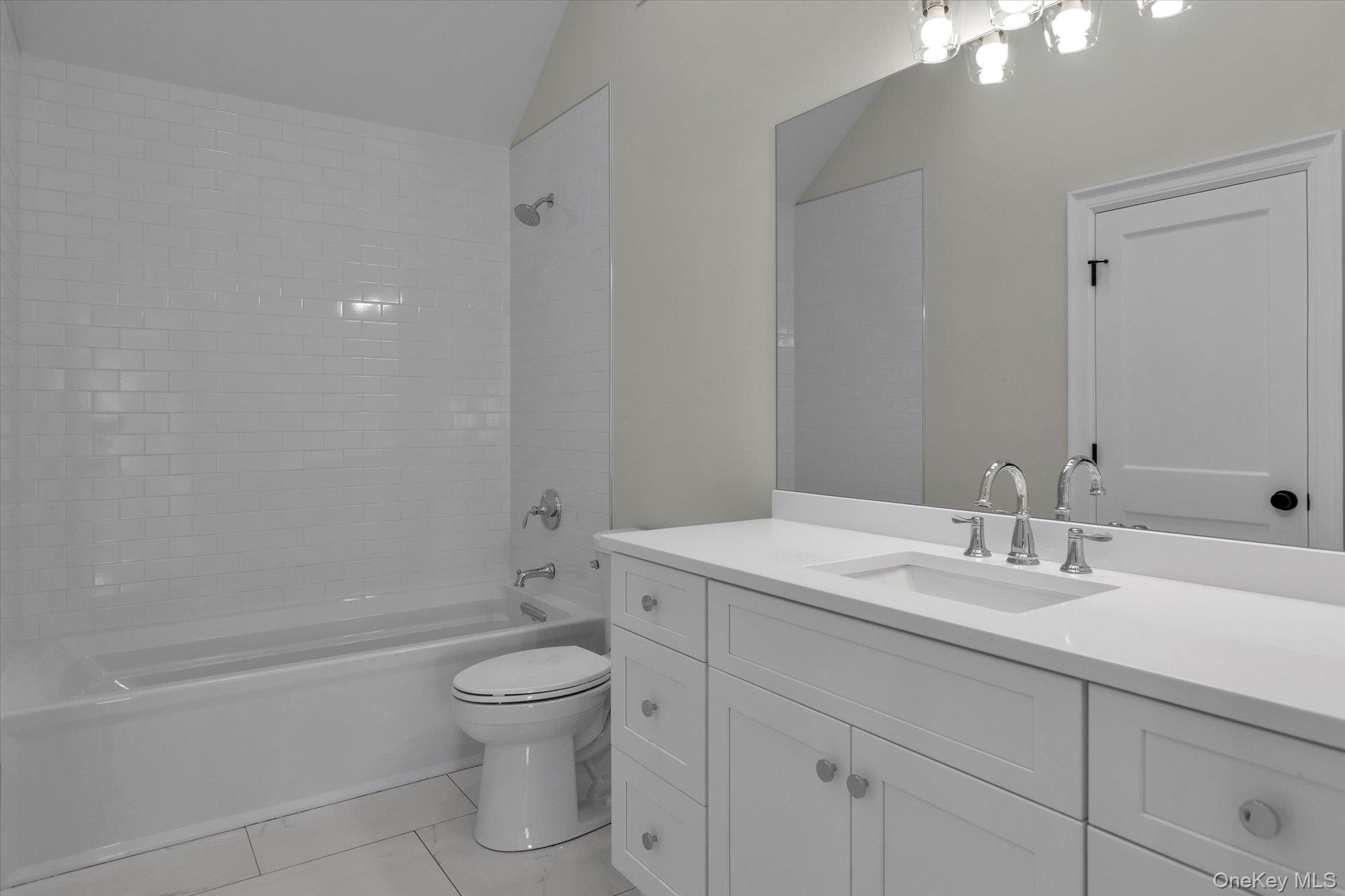 44 North Woodhull Road Huntington, NY 11743 - Photo 25 of 26 Full bathroom featuring vanity, tub / shower combination, vaulted ceiling, and light tile patterned flooring