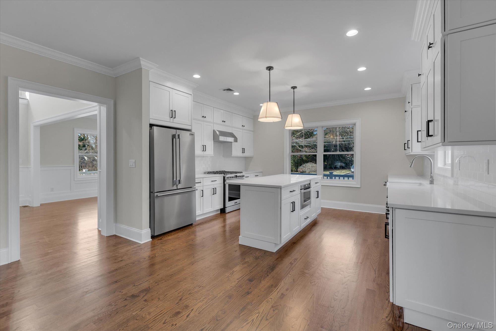 44 North Woodhull Road Huntington, NY 11743 - Photo 8 of 26 Kitchen featuring white cabinetry, stainless steel appliances, hanging light fixtures, healthy amount of natural light, and recessed lighting