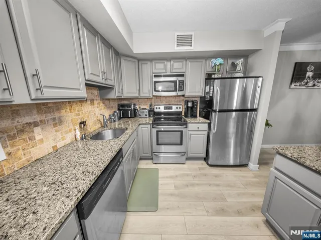 a kitchen with a refrigerator sink and cabinets