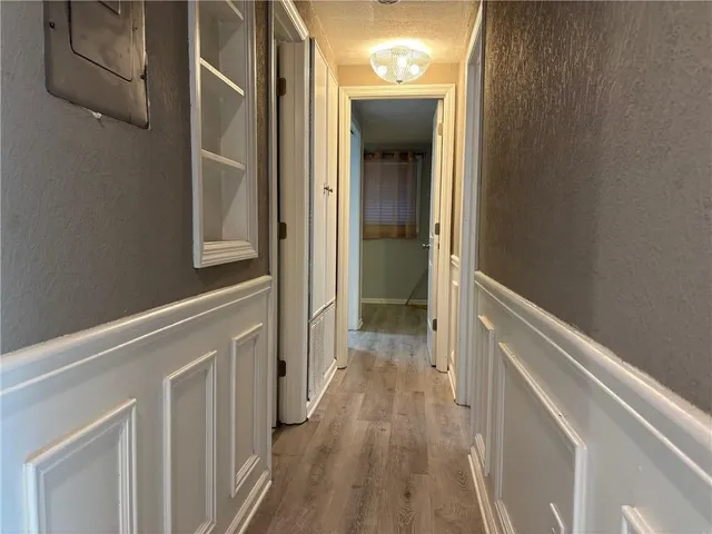 a view of a hallway with wooden floor and staircase