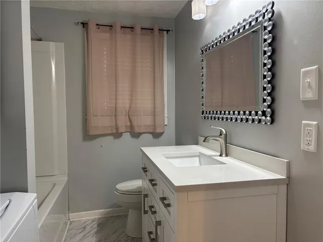 a bathroom with a sink a toilet and a mirror