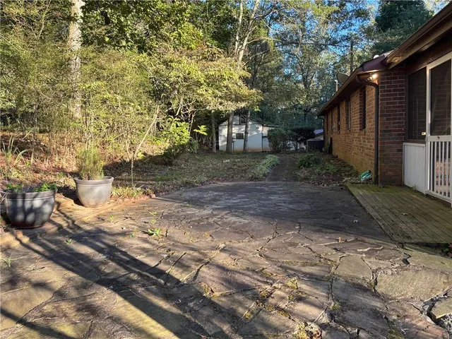 a view of a yard with plants and trees