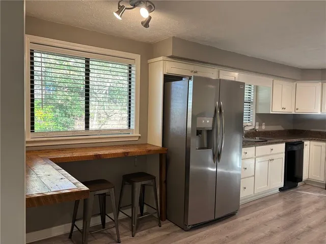 a kitchen with stainless steel appliances granite countertop a refrigerator and a stove top oven