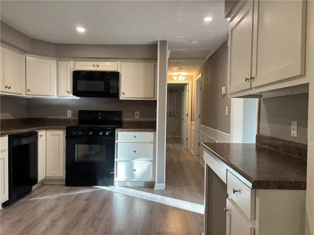 a kitchen with stainless steel appliances granite countertop a stove a refrigerator and a microwave