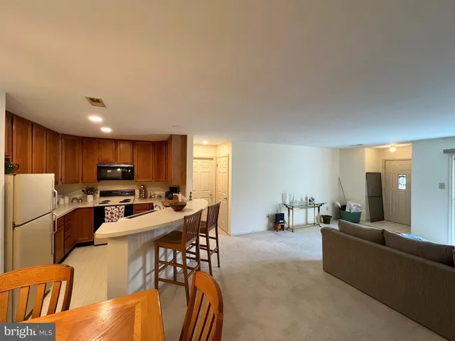 a view of a dining room with furniture a kitchen and chandelier