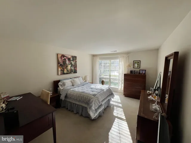 a bedroom with a bed dresser and a window