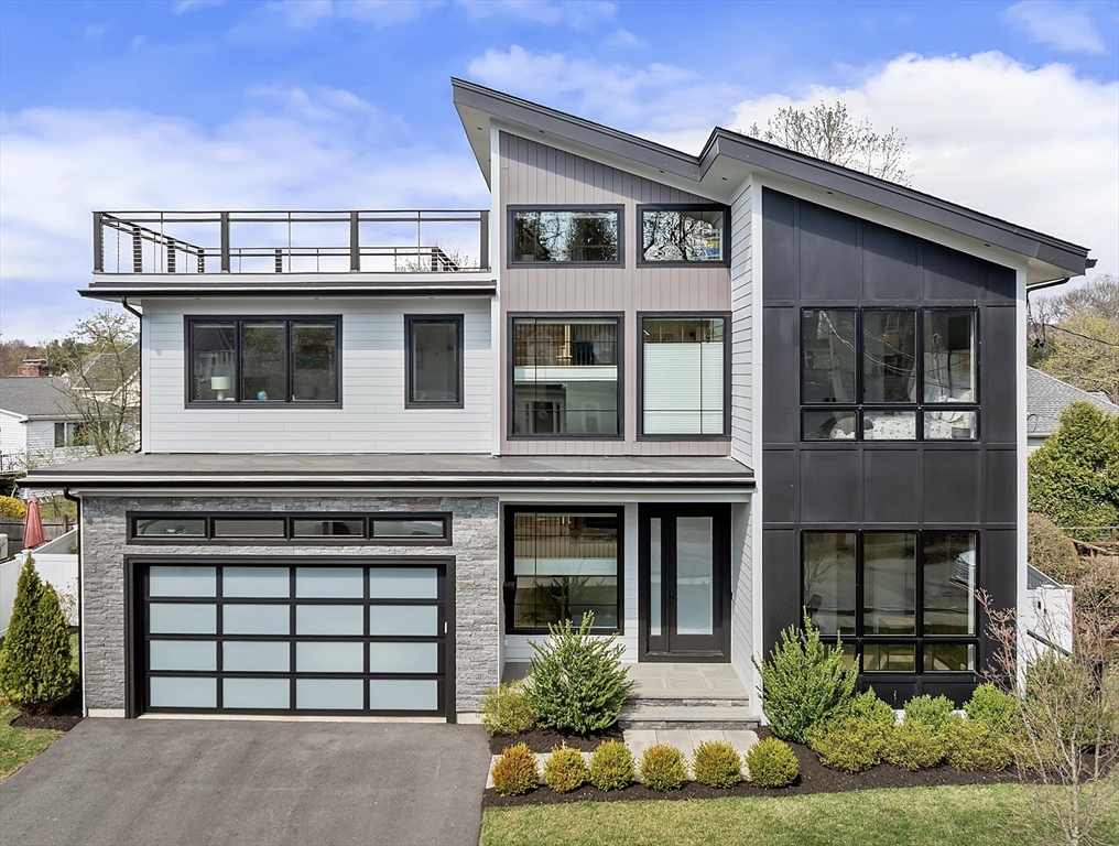 a front view of a house with a yard and plants