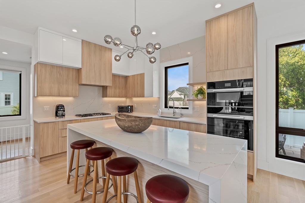 9 Whittlesey Road Newton, MA 02459 - Photo 6 of 33 a kitchen with stainless steel appliances granite countertop a stove refrigerator a sink dishwasher and white cabinets with wooden floor