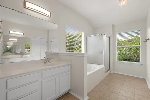 a bathroom with a tub sink and mirror