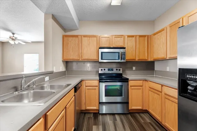 a kitchen with stainless steel appliances a sink a stove cabinets and a microwave