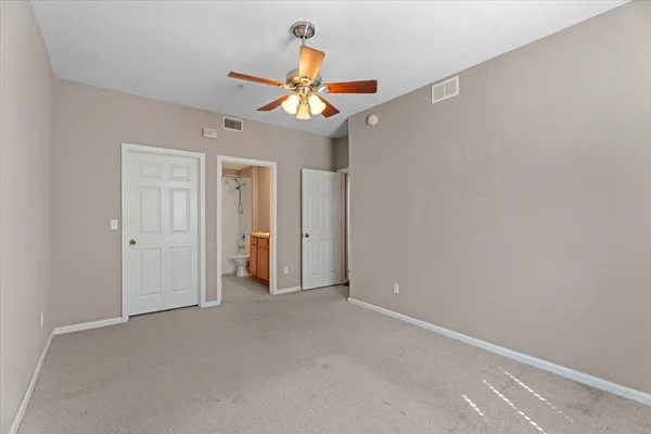 a view of an empty room with a ceiling fan