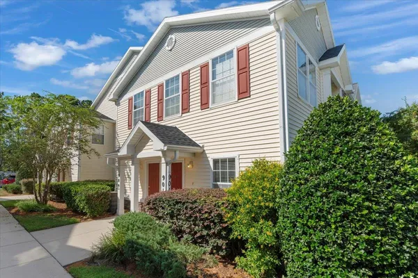 a view of a white house next to a yard