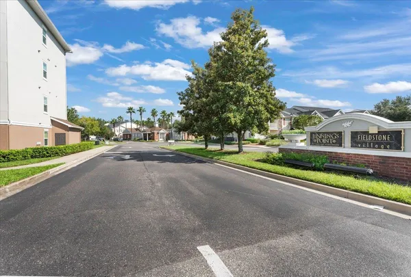 a front view of a house with a garden and trees
