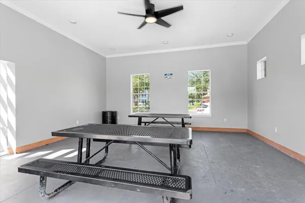 a room with table chairs and windows