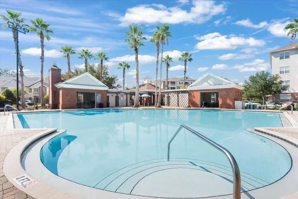 a view of a swimming pool with a lawn chairs under an umbrella