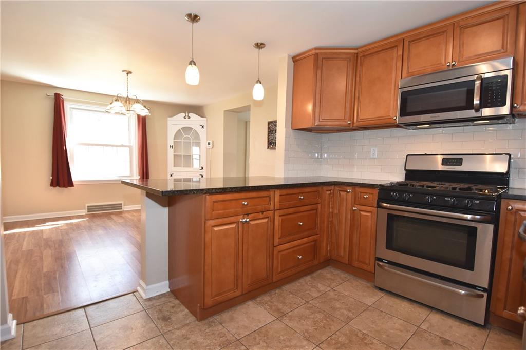 5470 Library Road Bethel Park, PA 15102 - Photo 10 of 24 a kitchen with stainless steel appliances granite countertop a stove a sink and a microwave
