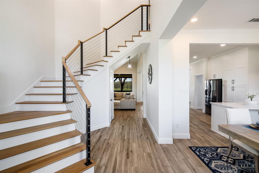 245 Barnes Bridge Road Sunnyvale, TX 75182 - Photo 5 of 40 The foyer features a striking modern wood staircase, where minimalist cable railings create an open, airy feel.