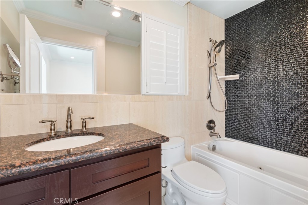 21819 Chestnut Court Walnut, CA 91789 - Photo 28 of 32 a bathroom with a granite countertop toilet a sink and a bathtub