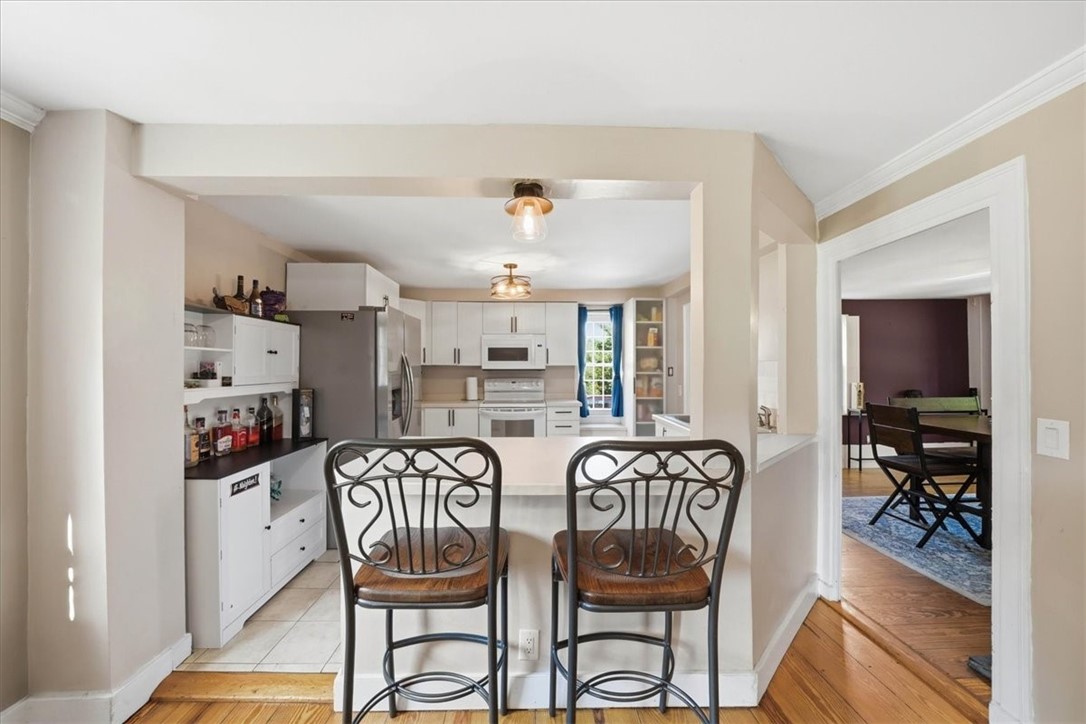 32 Equestrian Way Cranston, RI 02921 - Photo 13 of 50 A casual breakfast bar bridges the kitchen and living area, making the layout equally suited to everyday routines and social gatherings. The connected layout allows meals and conversation to flow easily between the kitchen, dining room and living room.