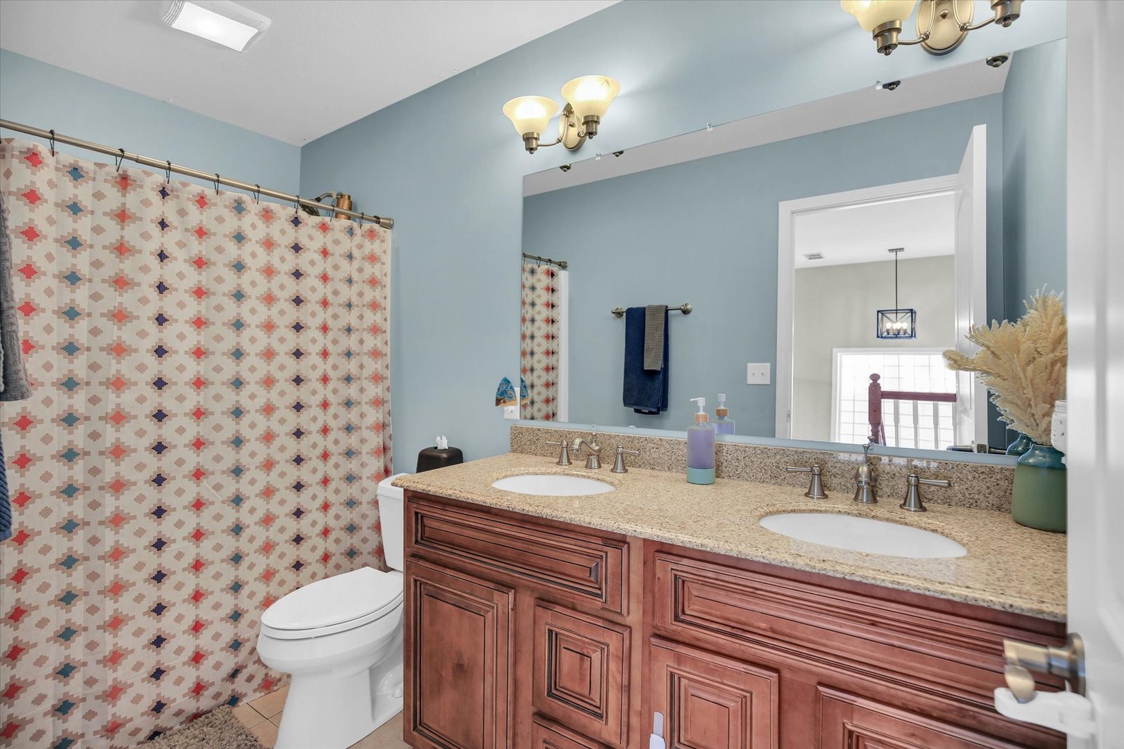 1315 West Ridge Lane Champaign, IL 61822 - Photo 68 of 102 a bathroom with a granite countertop toilet a sink a mirror a window and a shower