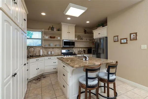 a kitchen with sink refrigerator and cabinets