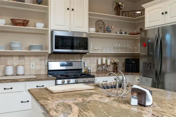 a kitchen with a stove a sink and a microwave