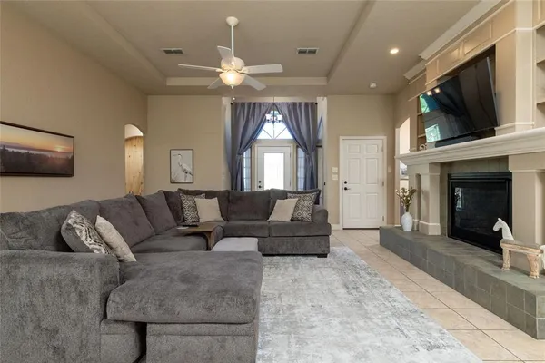 a living room with furniture a flat screen tv and a fireplace