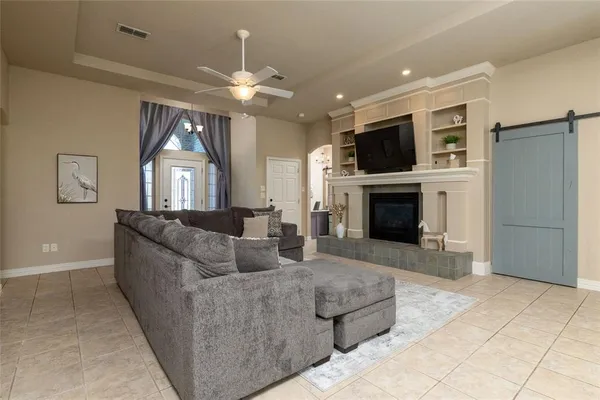 a living room with furniture a flat screen tv and a fireplace