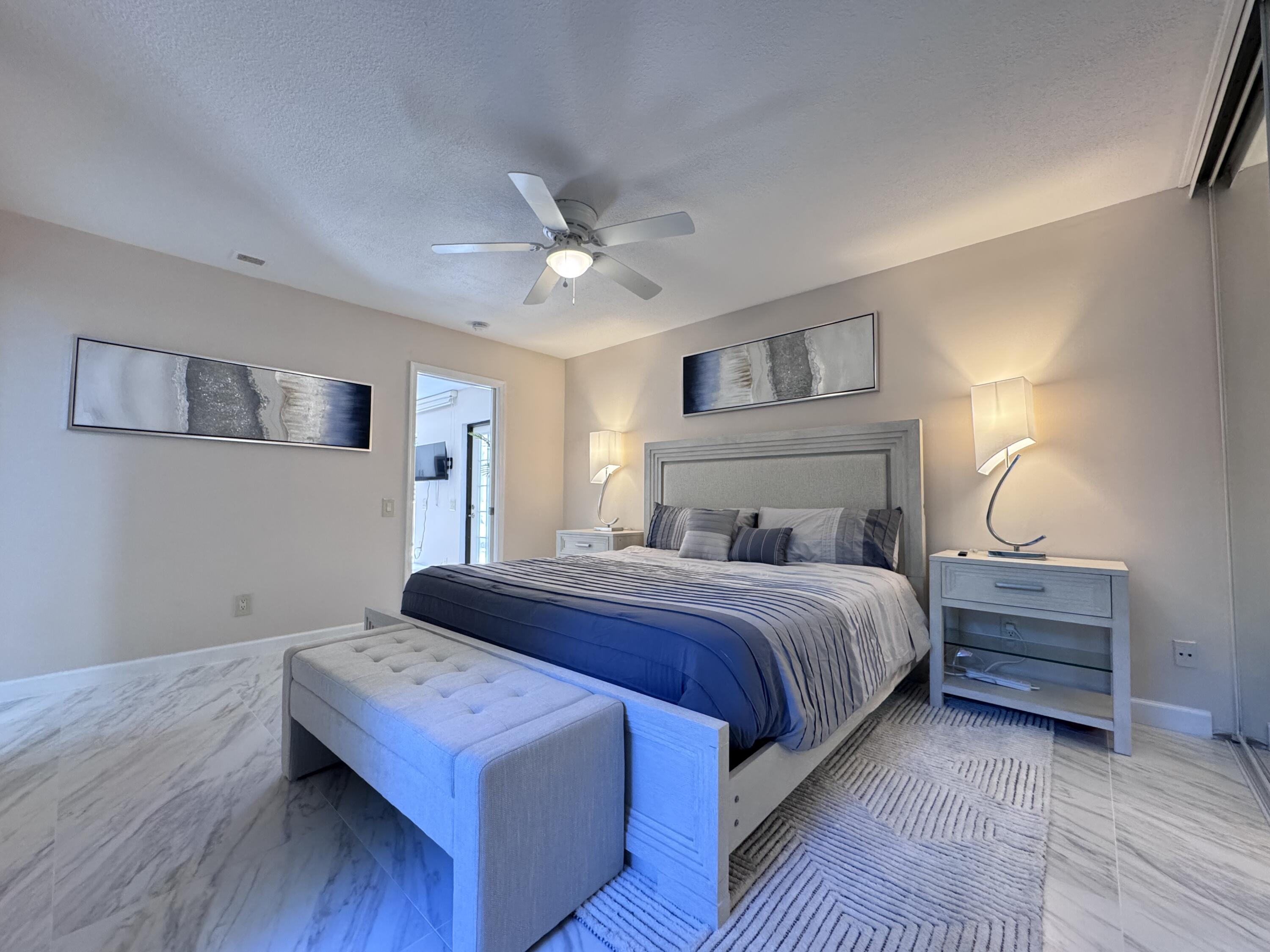 1605 Highway 1, Unit 1A Jupiter, FL 33477 - Photo 11 of 23 a bedroom with a bed and a chandelier