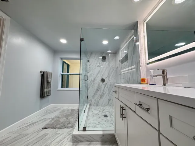 a bathroom with a shower sink and mirror