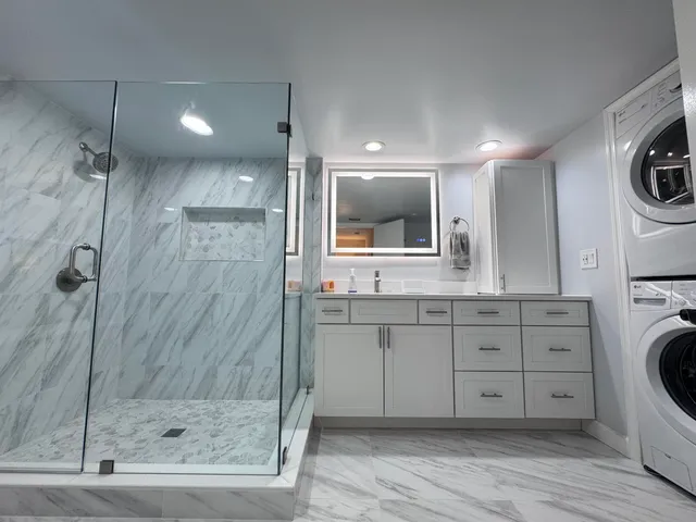 a bathroom with a granite countertop sink mirror and shower