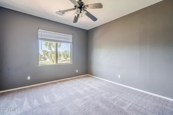 a view of a livingroom with wooden floor and a ceiling fan