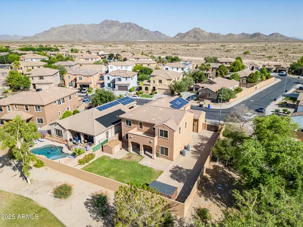 an aerial view of residential houses with outdoor space and trees